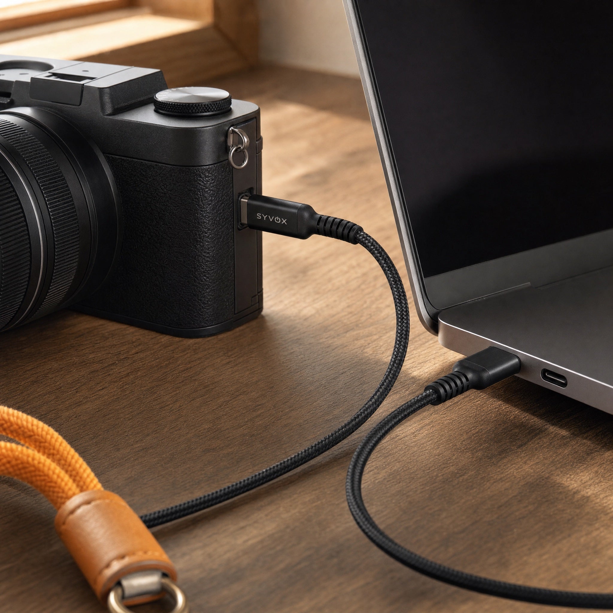Camera gekoppeld aan een laptop via de Power-kabel op een fotografenbureau