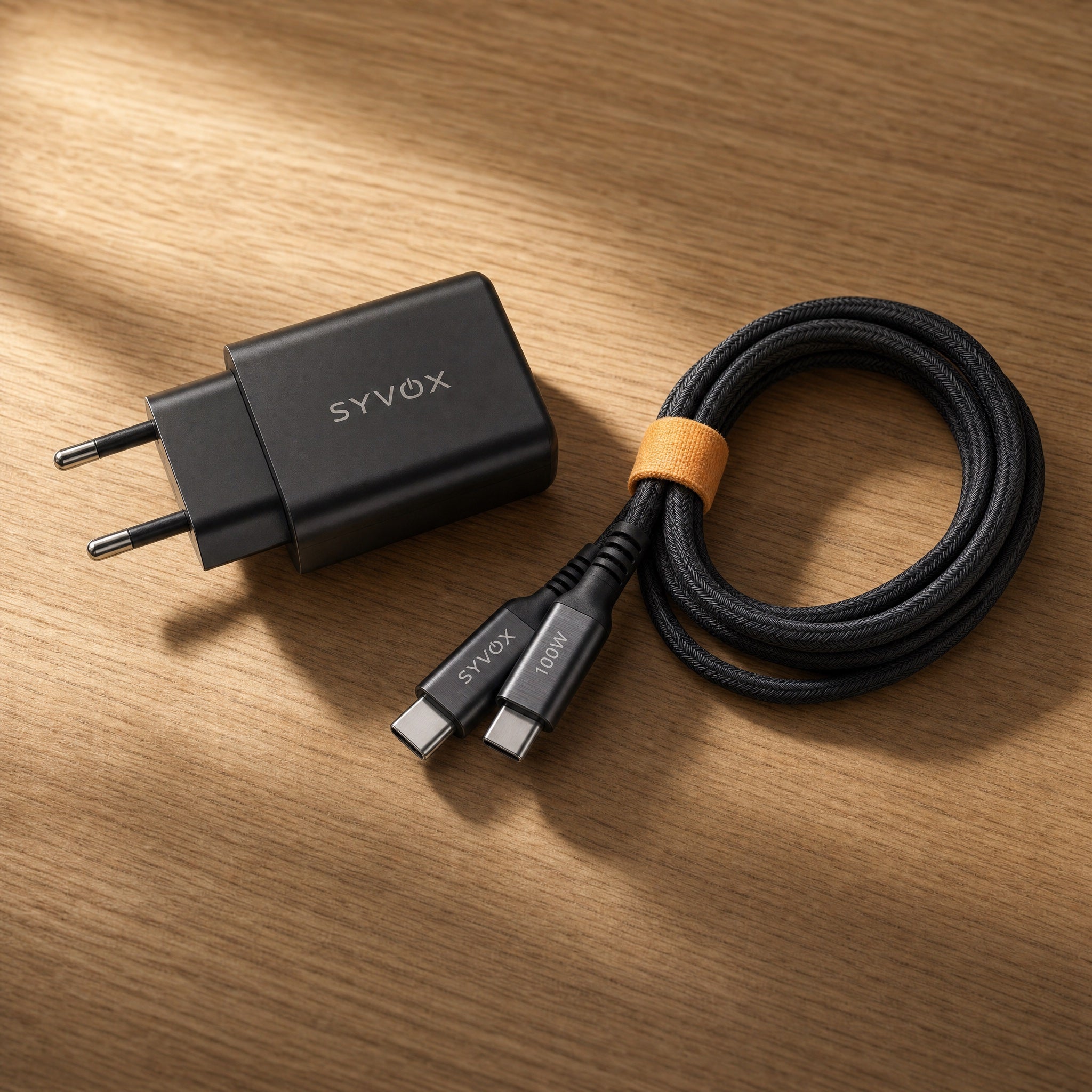 De 65W-snellader met opgerolde Essential-kabel